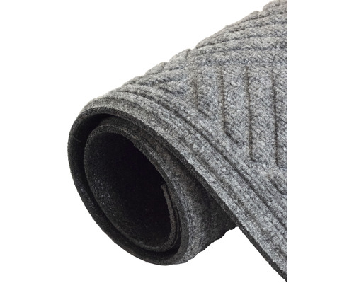 Paillasson gris à motif rainuré, enroulé.