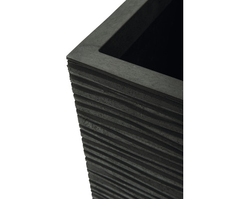 Gros plan d''un pot de fleurs noir avec un design rainuré.