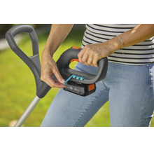 Eine Frau bedient einen Rasentrimmer mit Akku