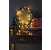Scène de Noël décorée avec couronne, lumières, cadeau et table