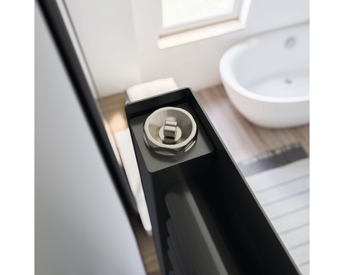 Detailaufnahme eines Heizkörperventils in einem Badezimmer mit Badewanne