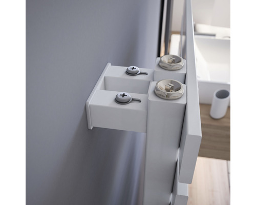 Detailaufnahme von einem weißen Badezimmerschrank mit Befestigung an einer grauen Wand.