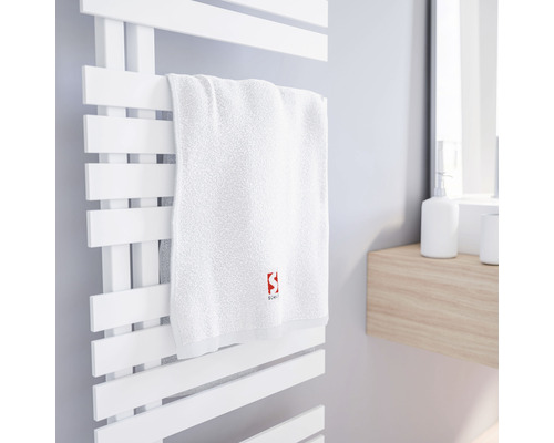 Weisses Handtuch auf einem weissen Handtuchwärmer im Badezimmer.
