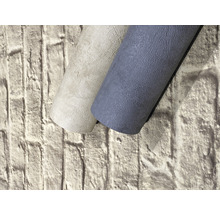 Deux rouleaux de papier peint texturé devant un mur en briques