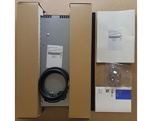 Induktionskochfeld mit Zubehör in Kartonverpackung.