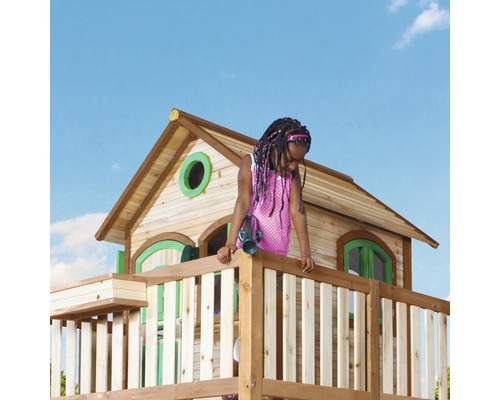 Fille sur une tour de jeu en bois avec maison