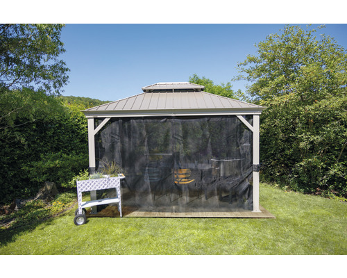 Gartenpavillon mit Moskitonetz und bepflanztem Rollwagen auf einer Rasenfläche.