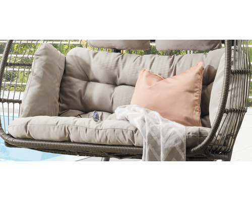 Gros plan d''un fauteuil suspendu avec coussins et couverture