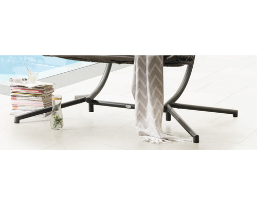 Vue détaillée de meubles de jardin avec une pile de magazines, une boisson et un tissu