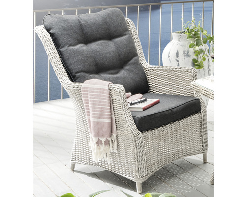 Rattansessel mit grauen Polstern und einer Decke auf einer Terrasse