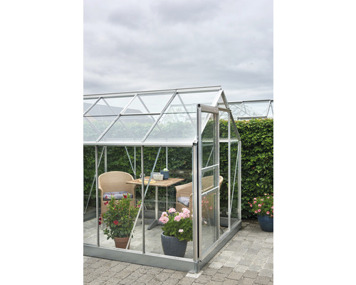 Serre avec meubles et plantes sur une surface pavée