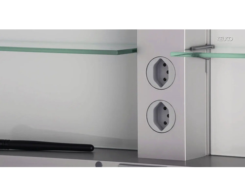 Detailansicht eines Spiegelschranks mit Steckdosen und Glasablagen.