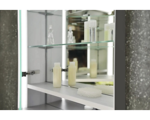 Armoire de toilette ouverte avec étagères en verre et accessoires de salle de bain