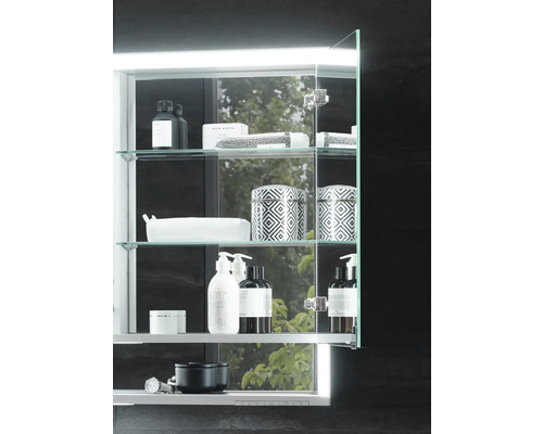 Scène de salle de bains avec armoire de toilette éclairée et accessoires de bain