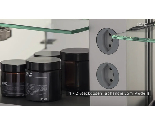 Innenansicht eines Spiegelschranks mit Glasablagen und Steckdosen