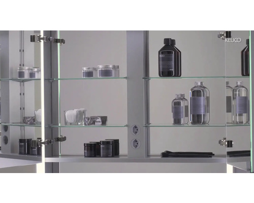 Scène de salle de bain avec armoire de toilette, étagères en verre et produits de soin