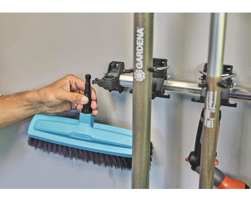 Gartenbesen mit Stielhalterung an einer Metallschiene