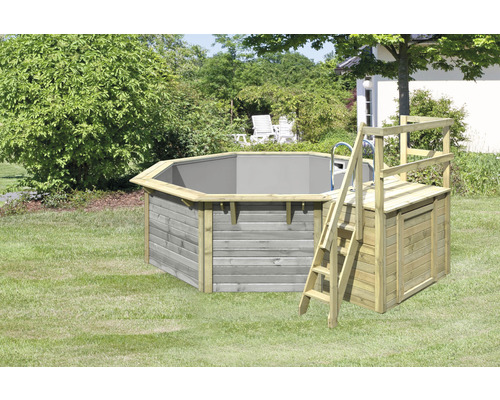 Piscine octogonale en bois avec échelle et coffre de rangement dans le jardin.