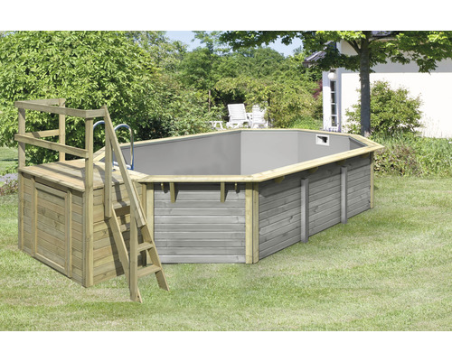 Piscine hors sol en bois avec échelle et plateforme dans le jardin.