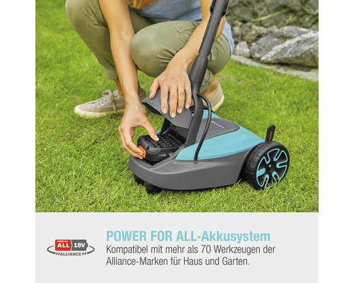 Frau setzt Akku in Rasenmäher ein