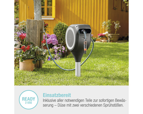 Gartenschlauchbox mit Schlauch und Bewässerungsdüse im Garten