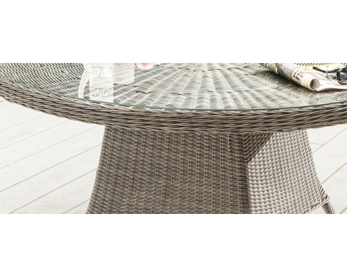Detailansicht eines runden Gartentisches mit Glasplatte und Rattanstruktur