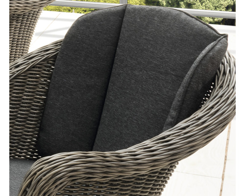 Detailaufnahme eines Rattansessels mit gepolstertem Sitzkissen und Rückenlehne