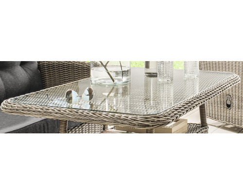 Nahaufnahme eines Rattantisches mit Glasplatte