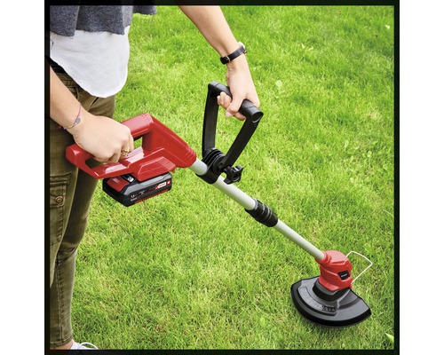 Une personne utilise un coupe-bordure dans le jardin.