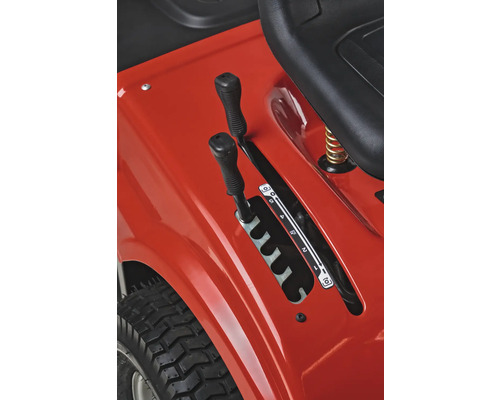 Gros plan du panneau de commande d''un tracteur de pelouse avec leviers de vitesses et sculpture des pneus