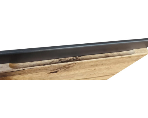 Detailaufnahme einer Holzplatte mit Griffmulde und einer schwarzen Leiste