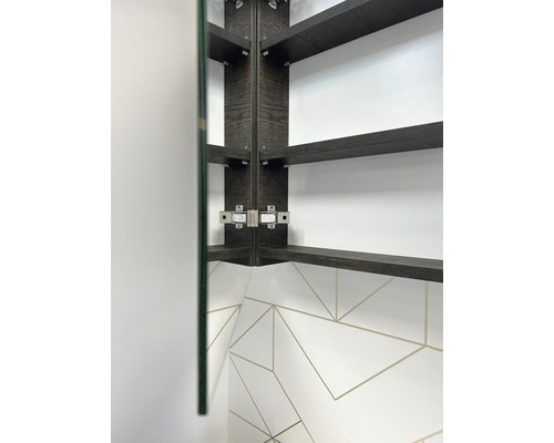 Innenansicht eines Spiegelschranks mit Holzregalen und einer geometrischen Fliesenkulisse