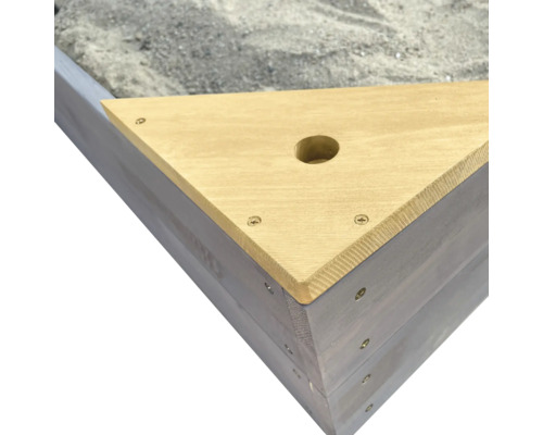 Vue détaillée d''un bac à sable triangulaire en bois avec perçage