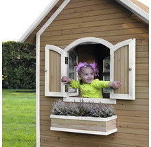 Fille dans une cabane en bois avec fenêtre et jardinière