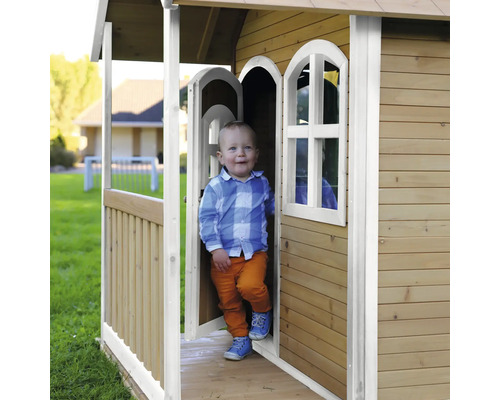 Enfant dans une cabane de jeux en bois dans le jardin