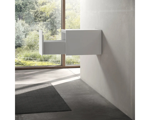 Meuble sous-vasque suspendu avec tiroir ouvert dans une salle de bains