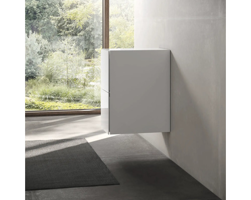 Meuble de salle de bain suspendu dans une pièce lumineuse avec fenêtre et tapis