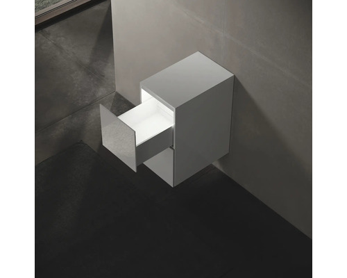 Meuble sous-lavabo suspendu avec tiroir ouvert dans la salle de bains.