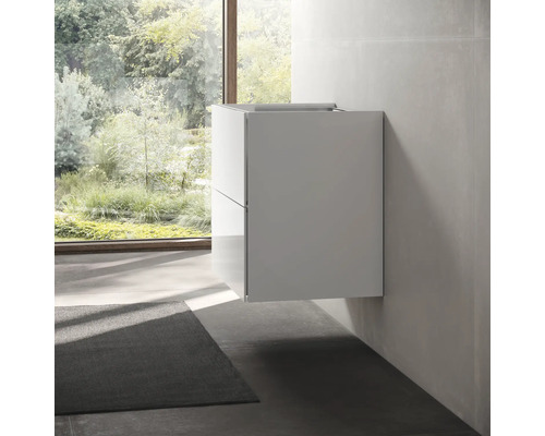 Salle de bains avec meuble sous-vasque moderne suspendu et vue sur la verdure par la fenêtre