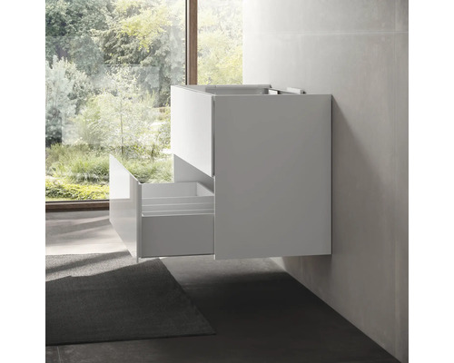 Meuble sous-lavabo suspendu avec tiroir ouvert dans une salle de bain.