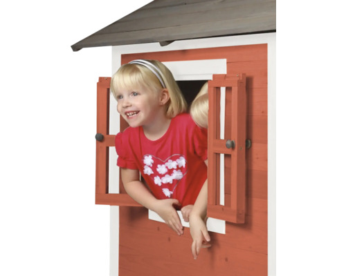 Enfant regardant par la fenêtre d''une cabane en bois