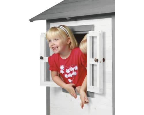 Kind schaut aus dem Fenster eines Spielhauses aus Holz