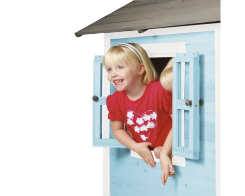 Fille regardant par la fenêtre d''une cabane de jeux