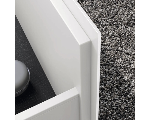 Detailansicht eines weißen Badezimmerschranks neben einem grauen Teppich