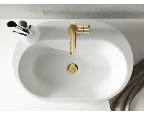 Vue de dessus d''un lavabo blanc avec un robinet doré et un récipient contenant des pinceaux de maquillage