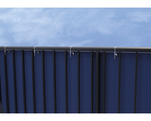 Detailansicht eines Sichtschutzes mit Befestigung an einem Geländer vor blauem Himmel.