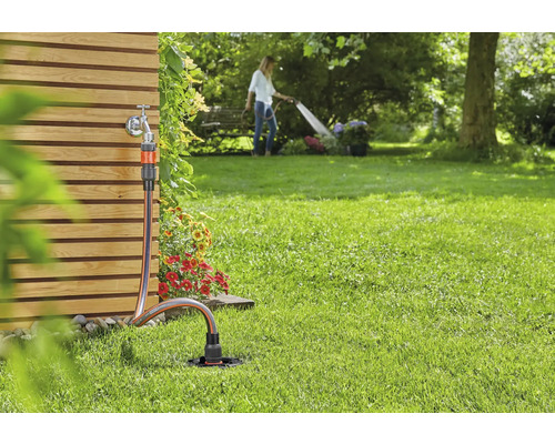 Scène de jardin avec robinet, tuyau d''arrosage et arroseur pour l''irrigation