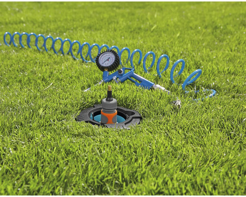 Arroseur escamotable avec pistolet à air comprimé et tuyau sur pelouse