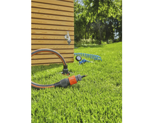 Scène de jardin avec robinet, tuyau d''arrosage et raccord sur une pelouse