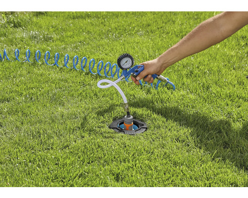 Un système d''arrosage installé dans la pelouse est vérifié avec un testeur d''air comprimé.